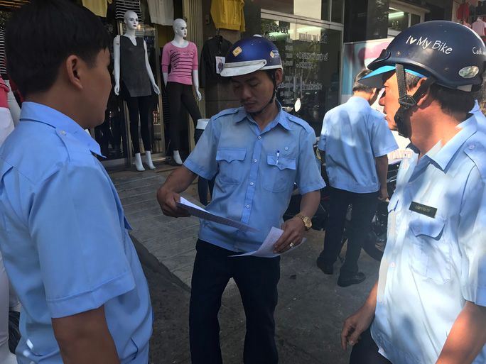 Lực lượng chức năng quận Tân Phú phát phiếu cam kết cho từng hộ dân đề nghị họ thực hiện nghiêm việc bảo đảm đường thông, hè thoáng.